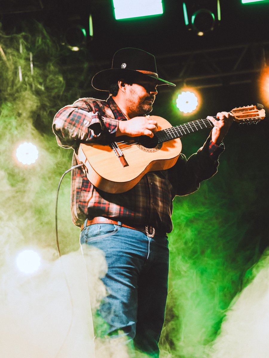 Violeiro Davi tocando sob as luzes do show